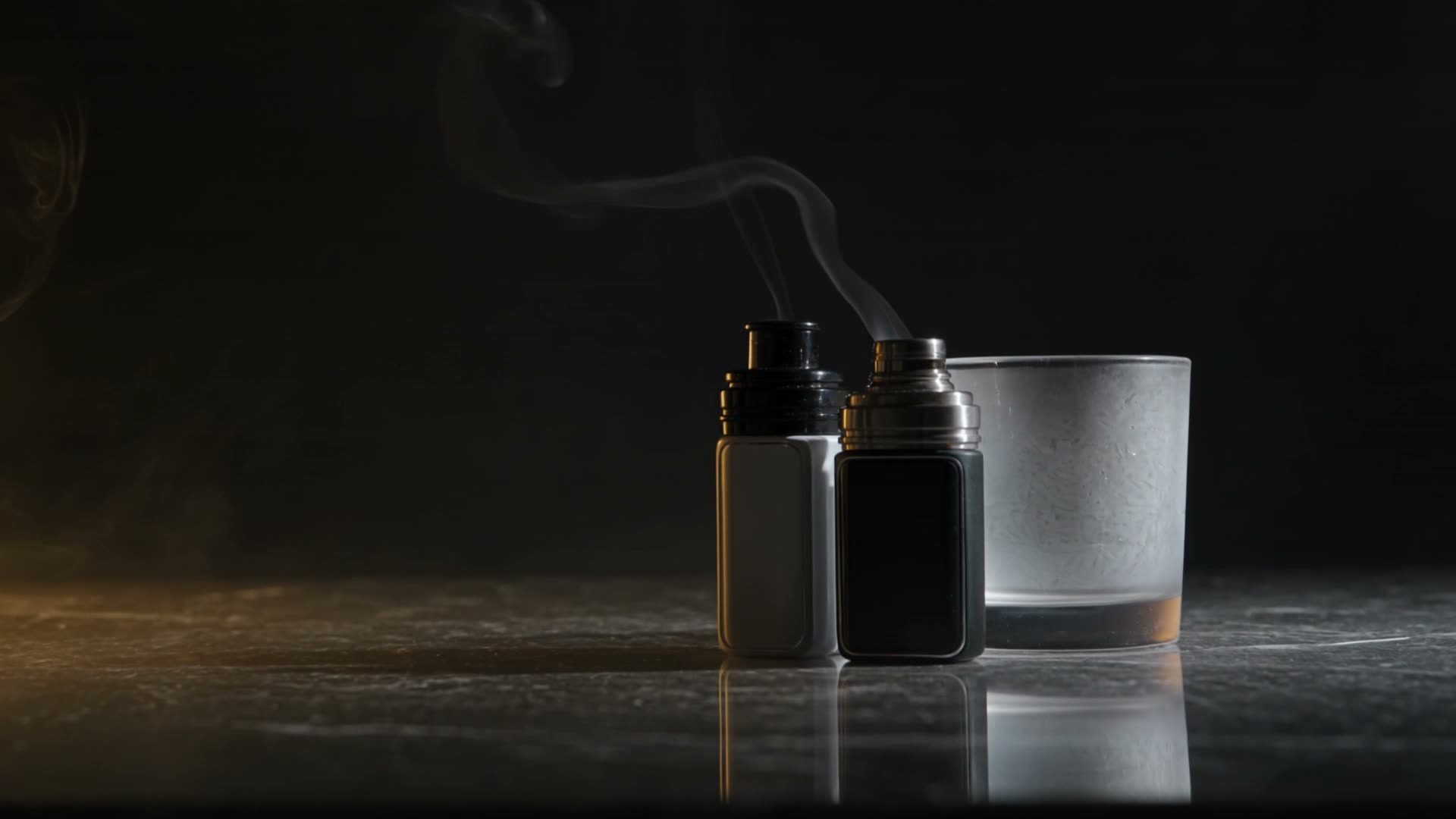 Vaporiser devices on dark stone with drifting vapour